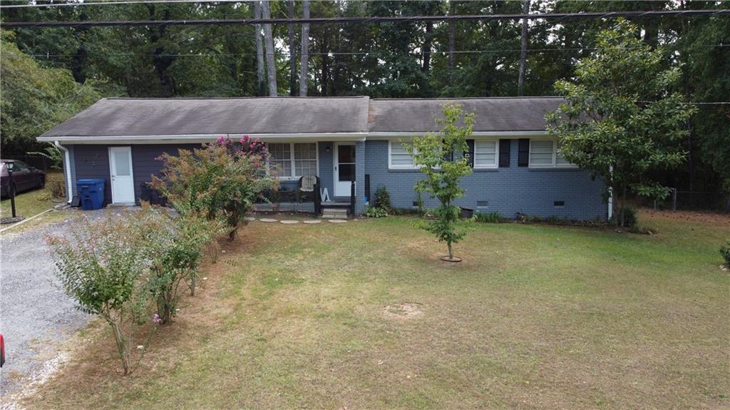 a view of house with yard and outdoor seating