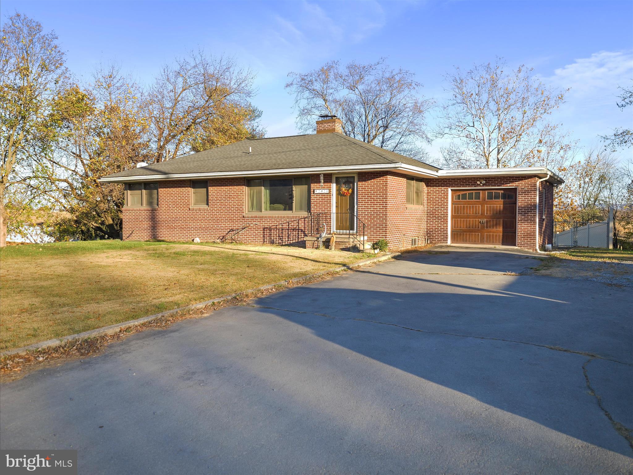 a front view of house with yard and trees in the background