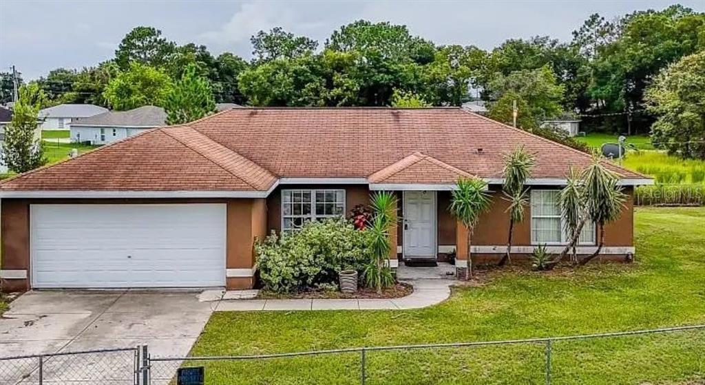 a backyard of a house with yard and trampoline