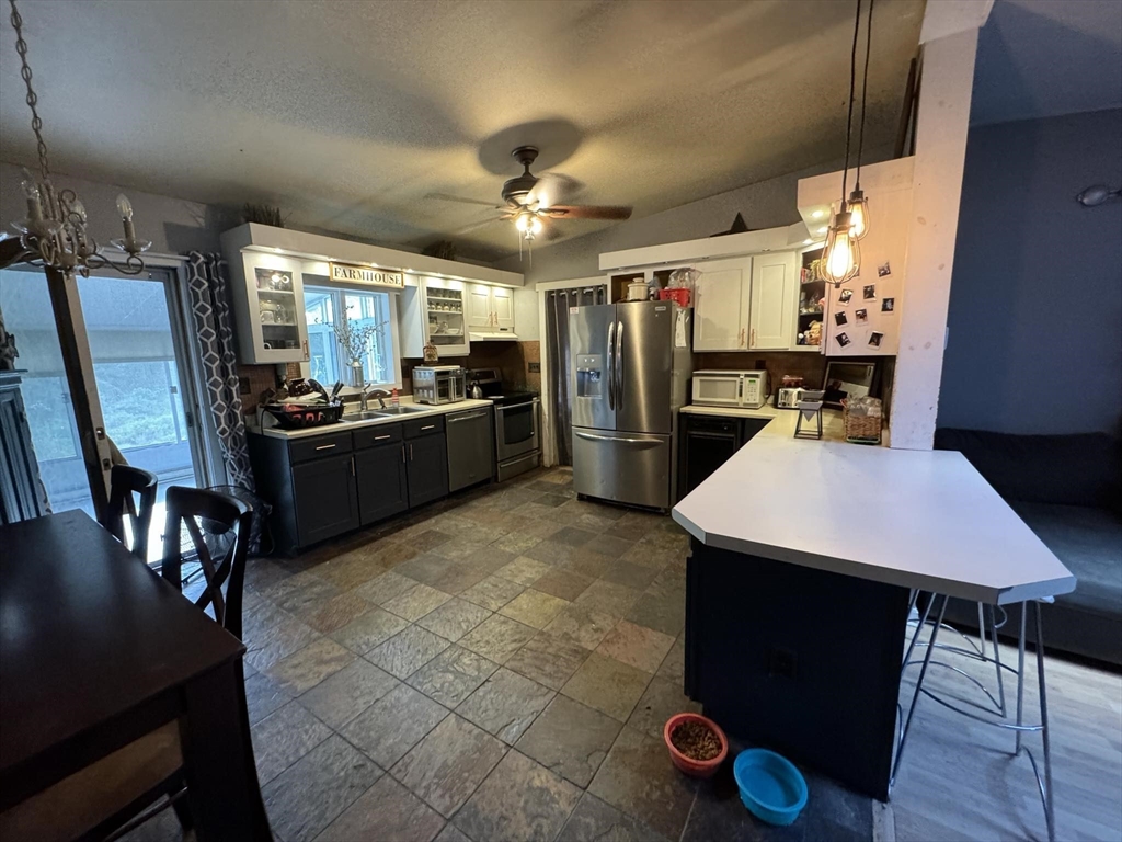 a kitchen with refrigerator and chairs