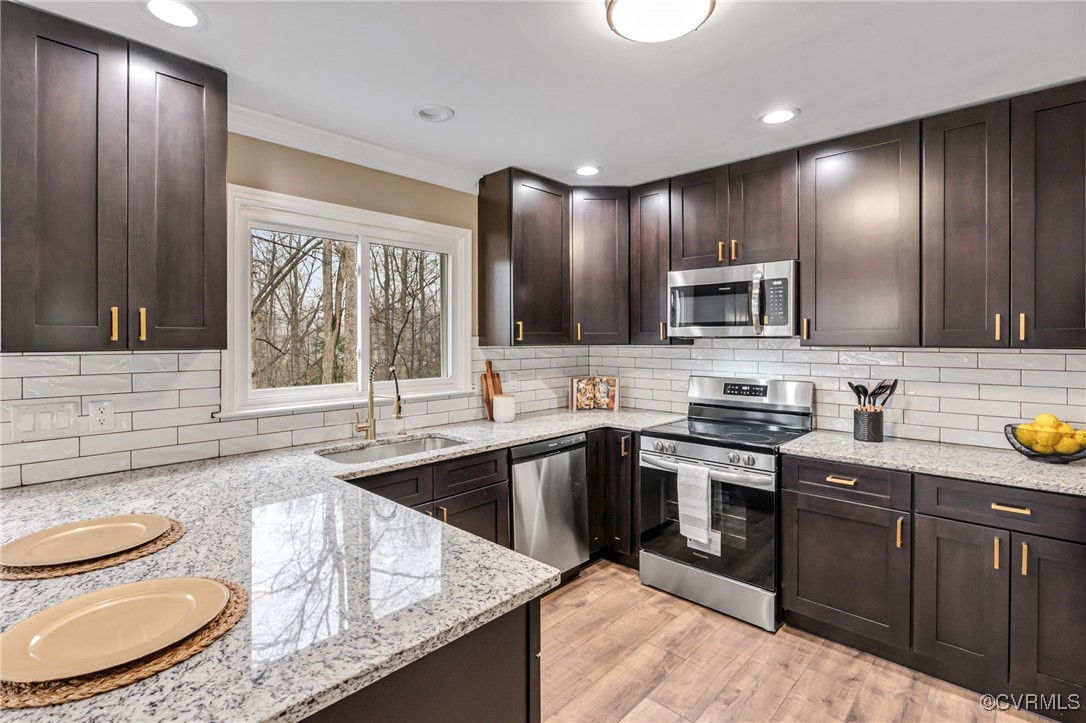 Kitchen featuring light stone countertops, sink, t