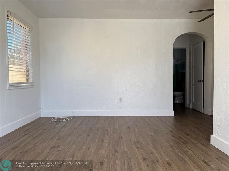 an empty room with wooden floor and a window