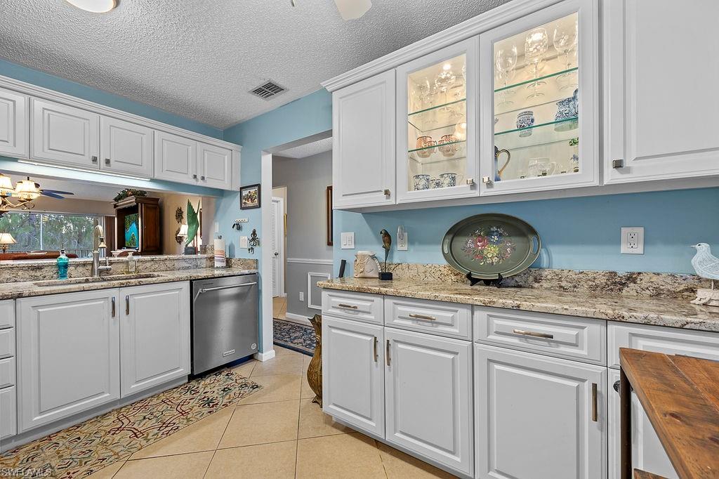 a kitchen with kitchen island granite countertop white cabinets and white appliances