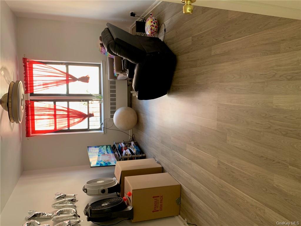 Sitting room with hardwood / wood-style floors and radiator heating unit