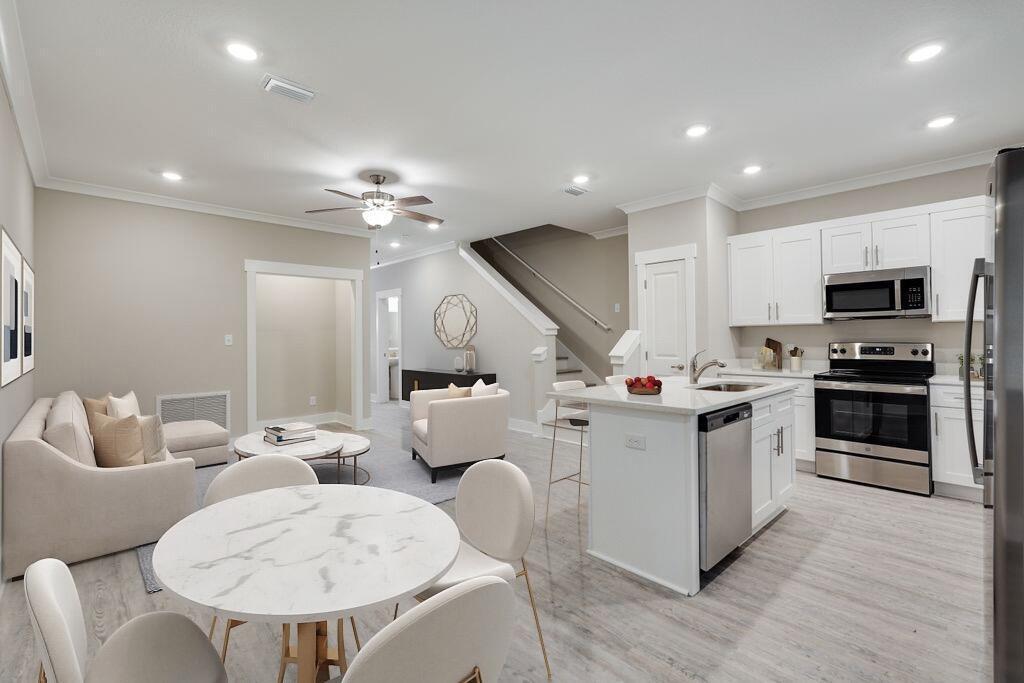 a kitchen with a sink stainless steel appliances and white cabinets