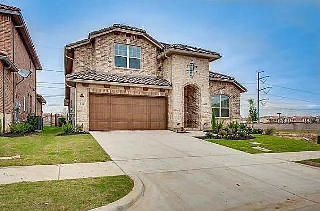 a front view of a house with a garden and garage