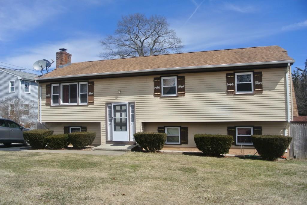 a front view of a house with yard and parking space