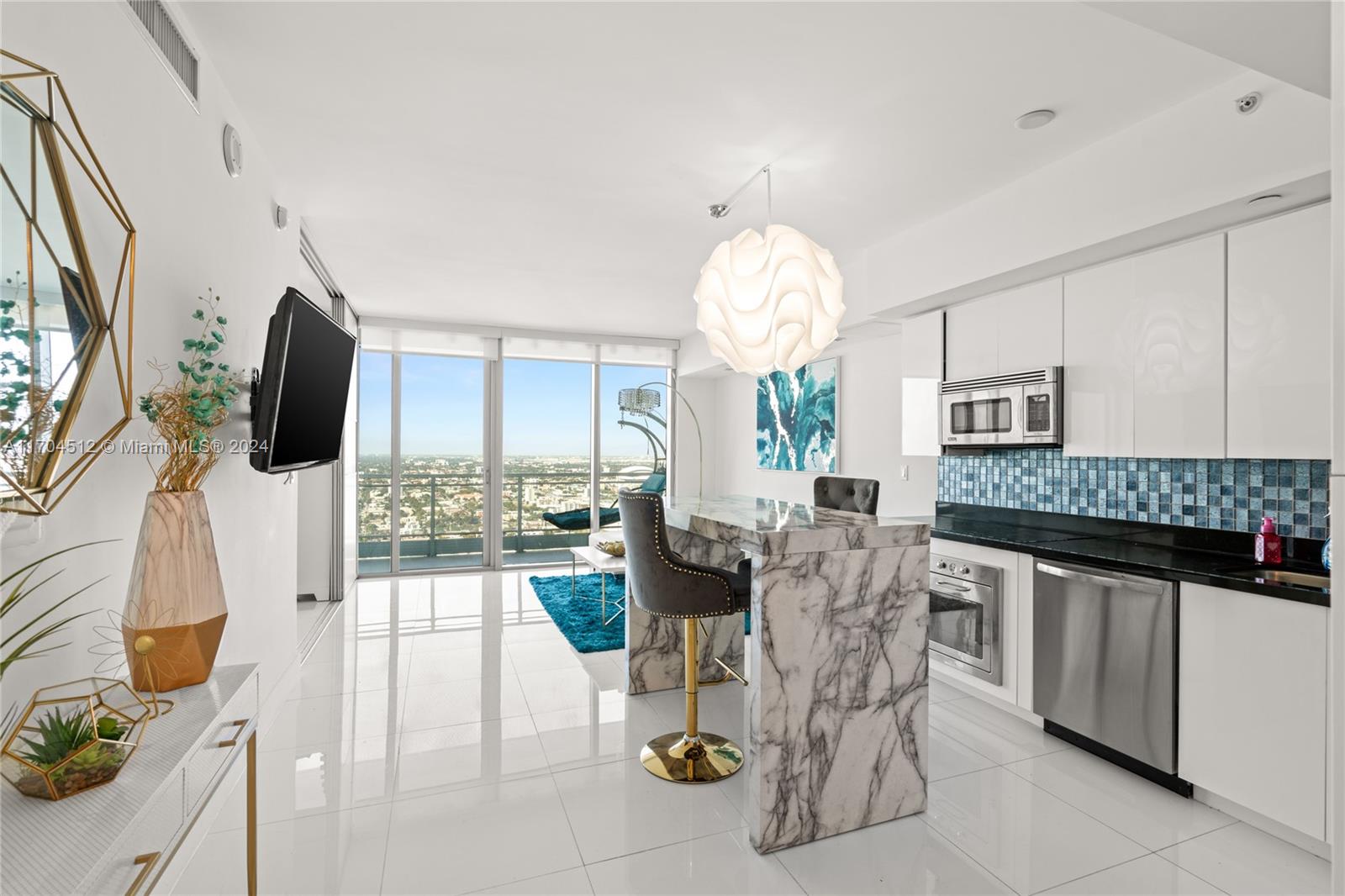 a living room with furniture a flat screen tv and a floor to ceiling window