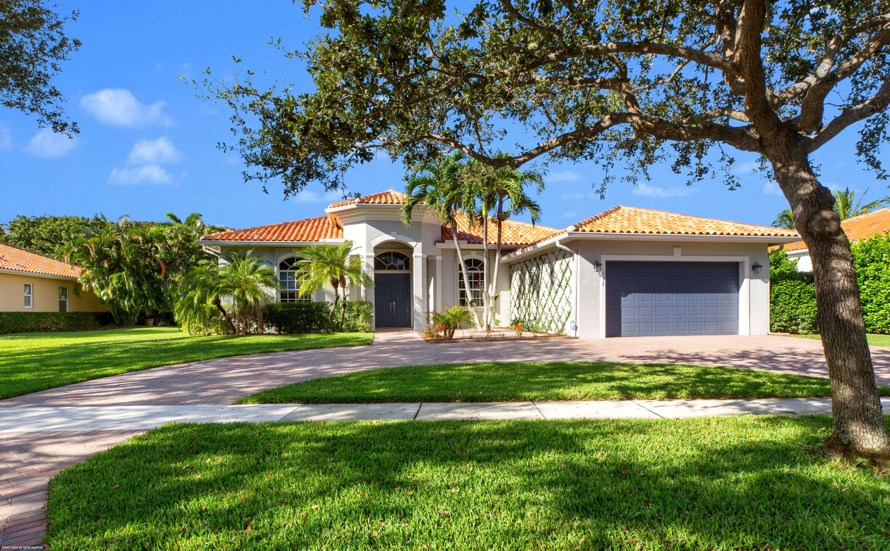 a front view of a house with a garden and trees