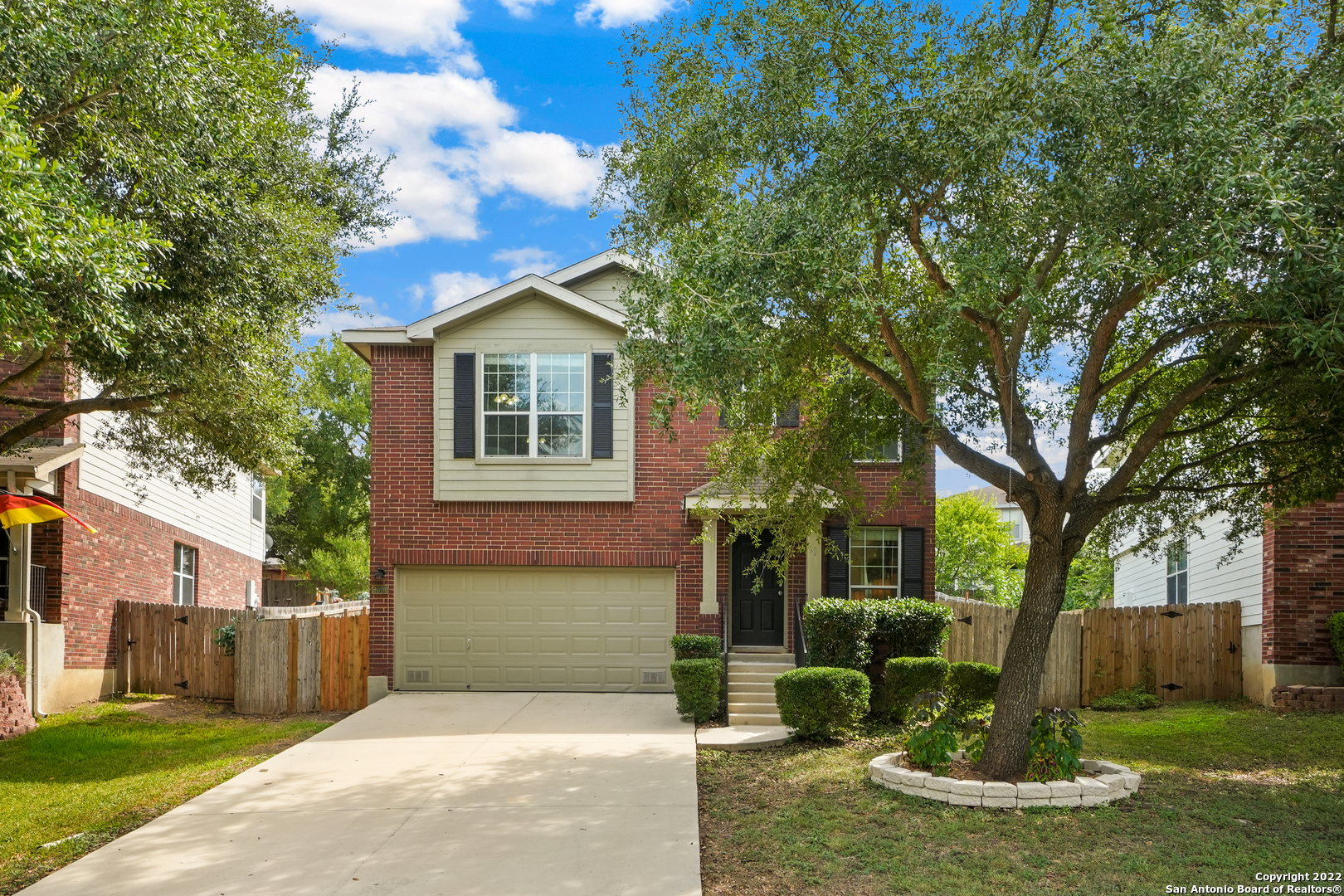 a view of a house with backyard and tree