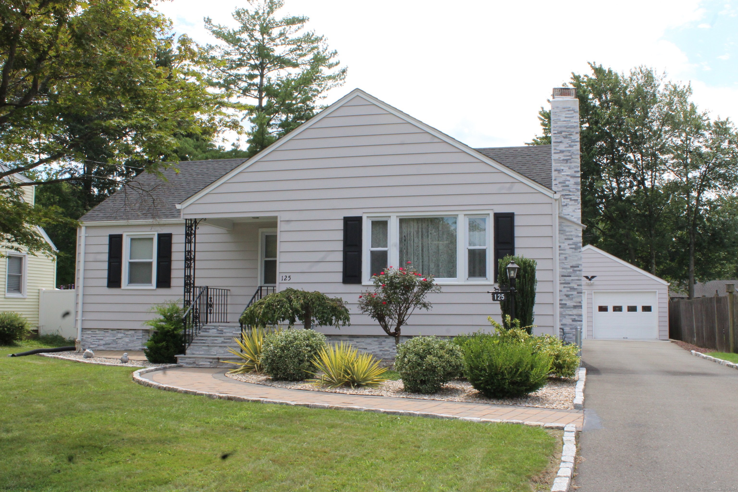 a front view of house with a garden and patio