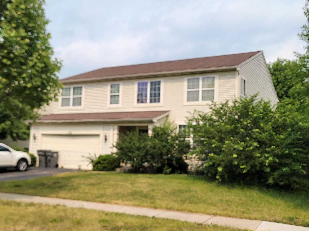 a front view of a house with a garden and yard