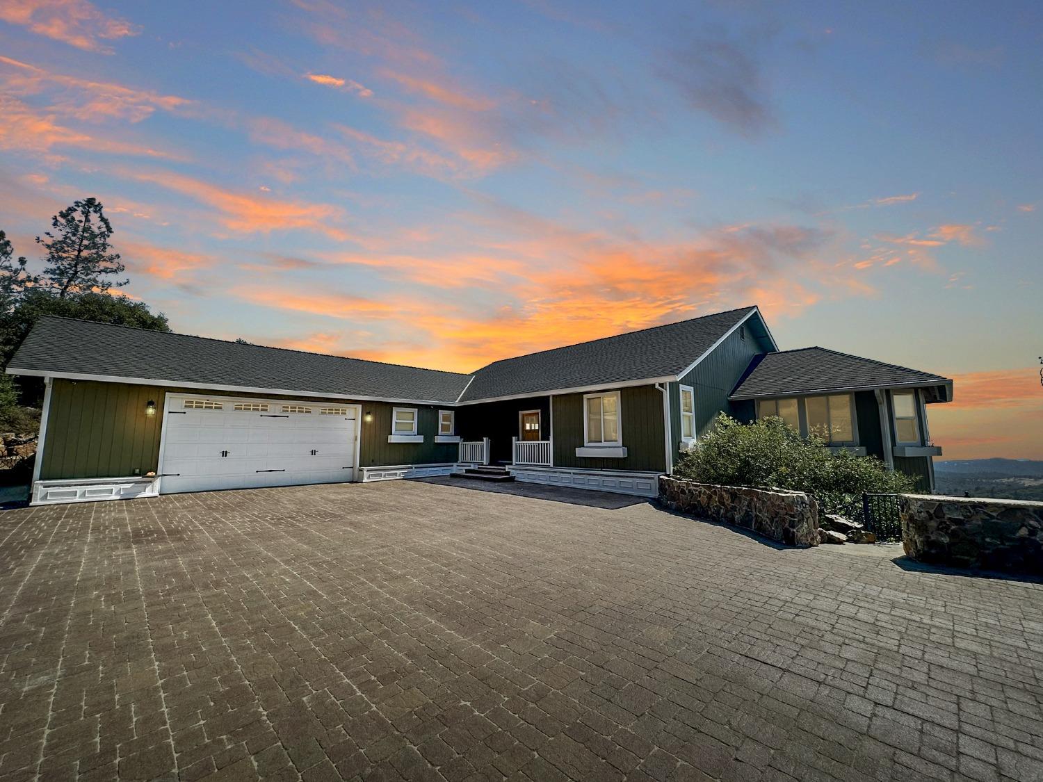 a front view of a house with yard and parking