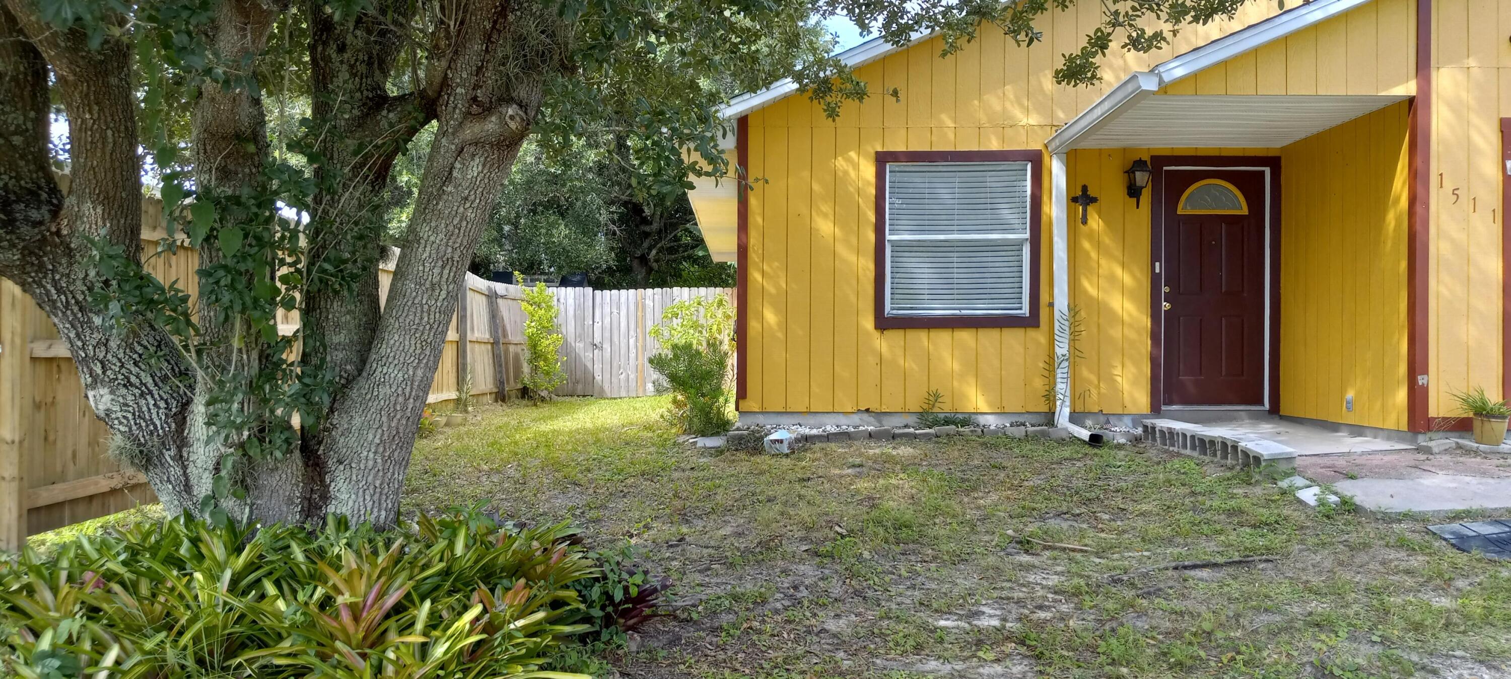 a view of a house with backyard and trees