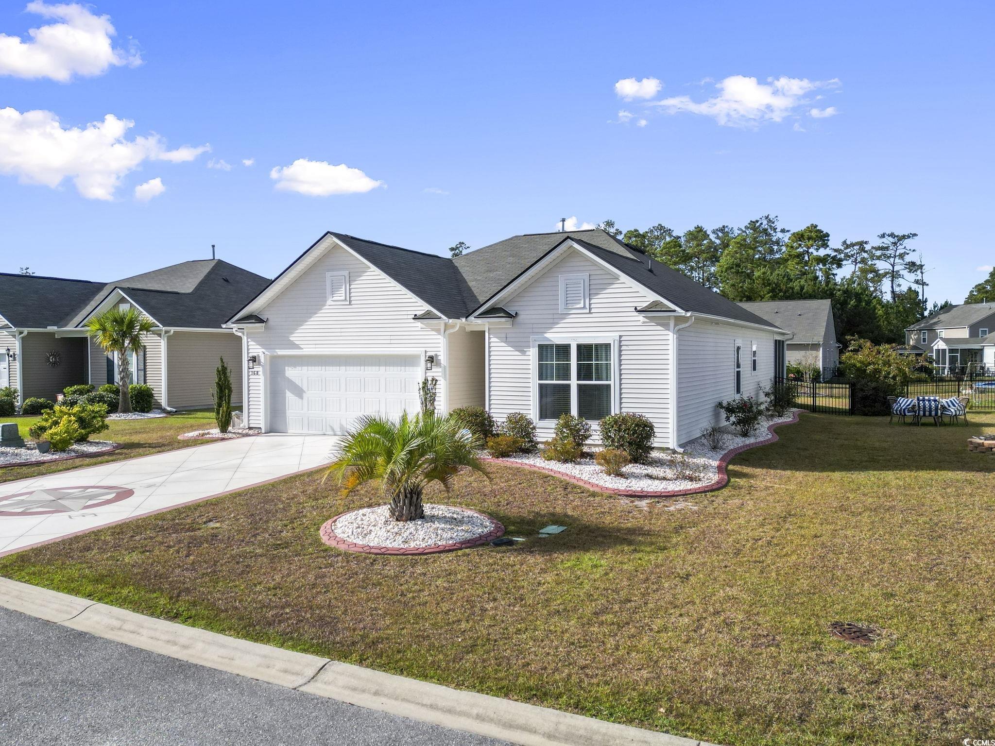 Single story home featuring a front yard and a gar