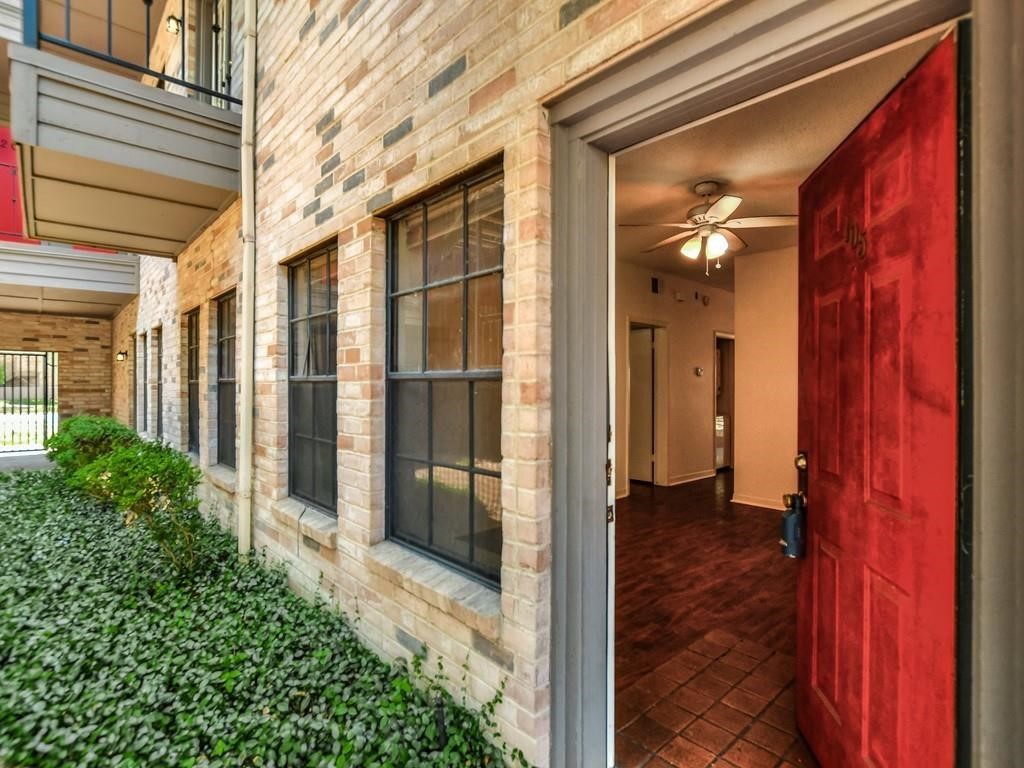 a view of a brick house with a glass door and chair