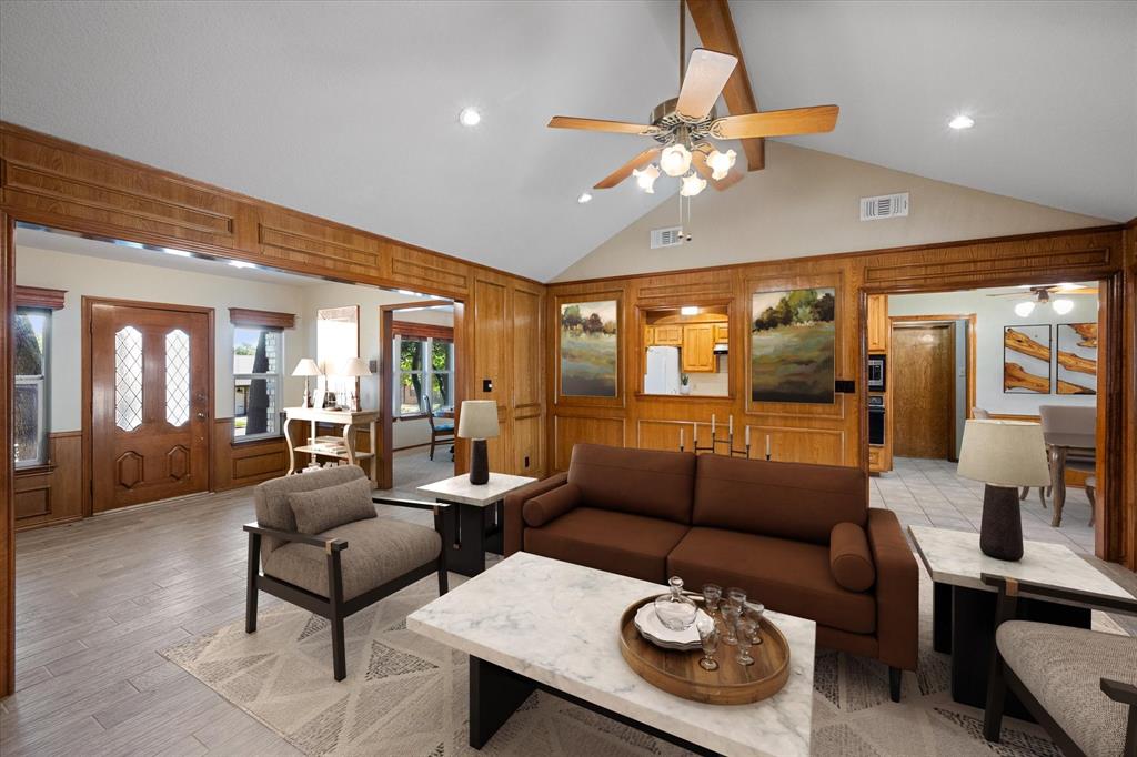 a living room with furniture a chandelier and a large mirror