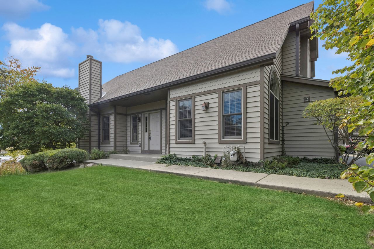 a front view of a house with a garden and plants