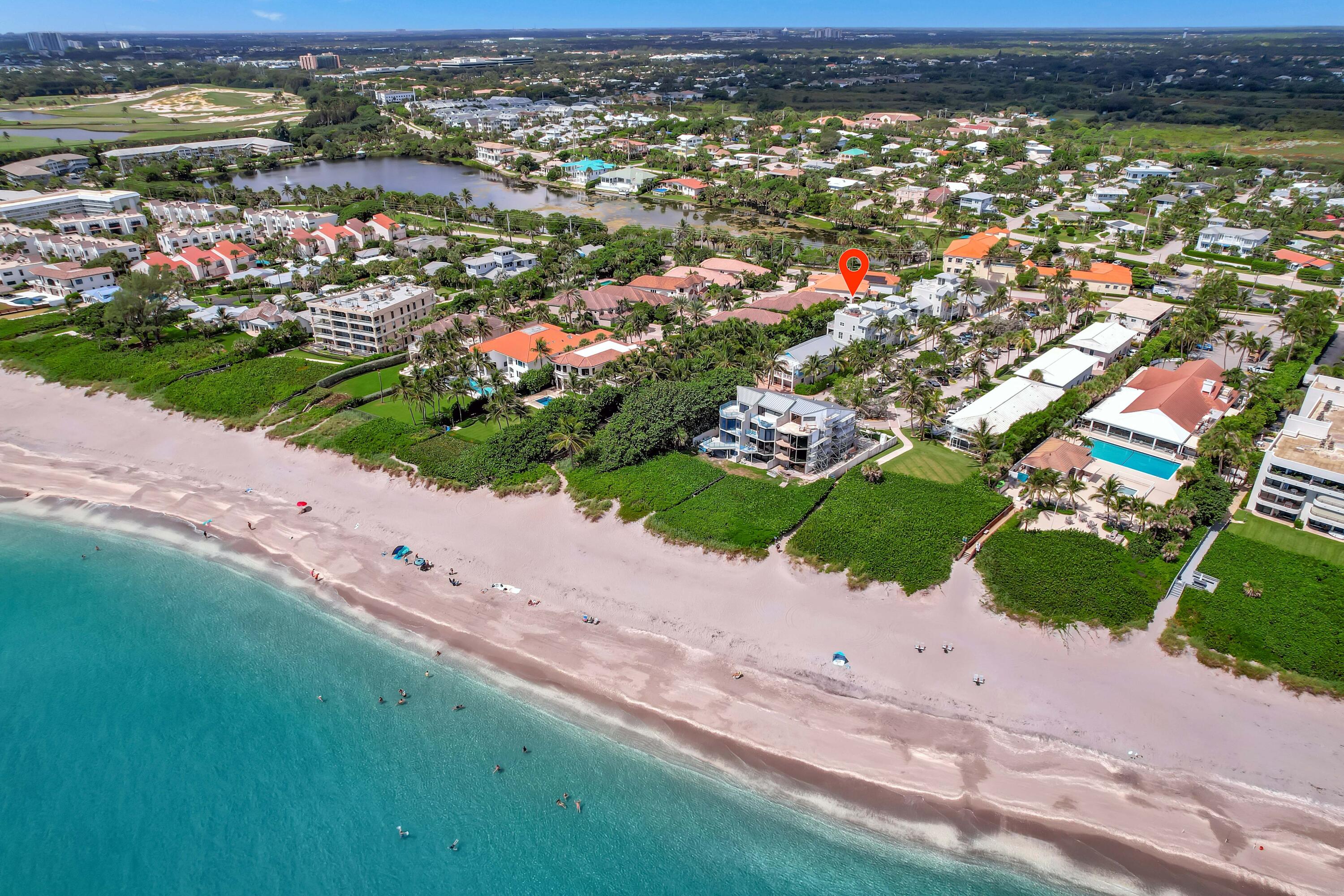 an aerial view of a city with lots of residential buildings ocean and mountain view in back