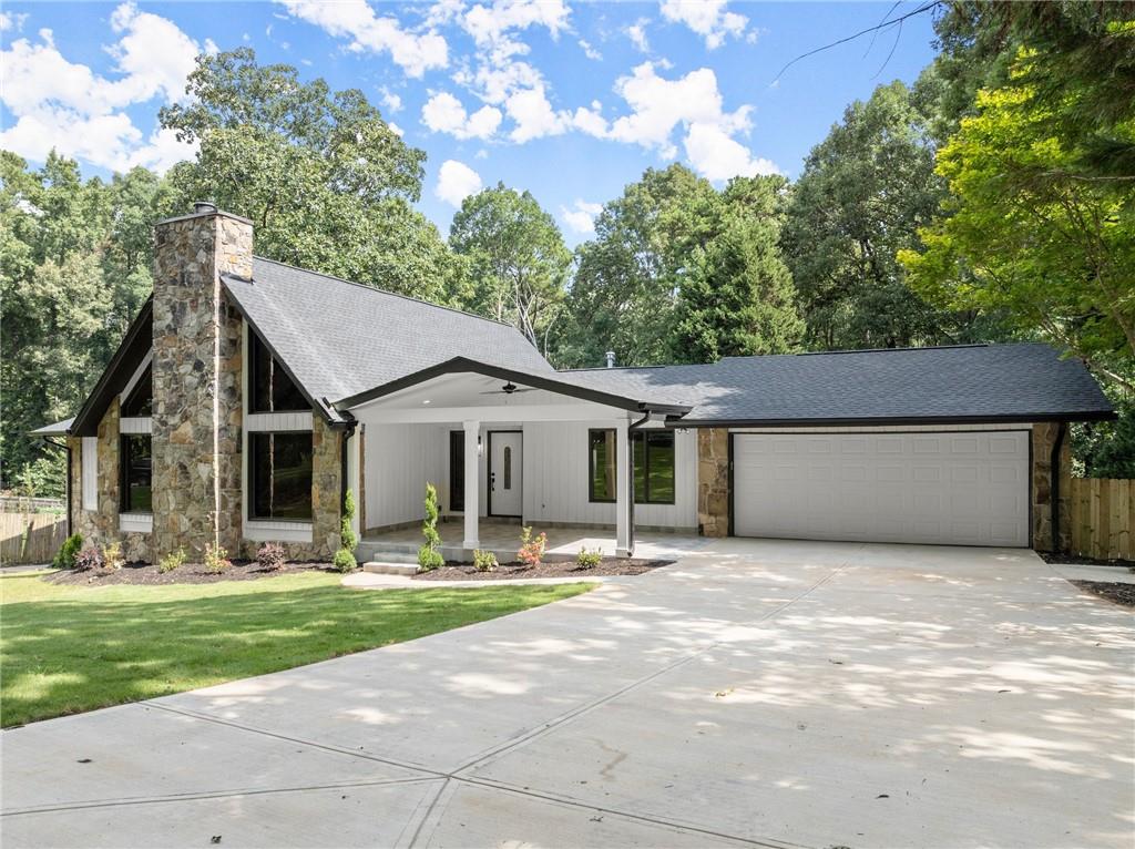 a front view of house with yard and trees in the background