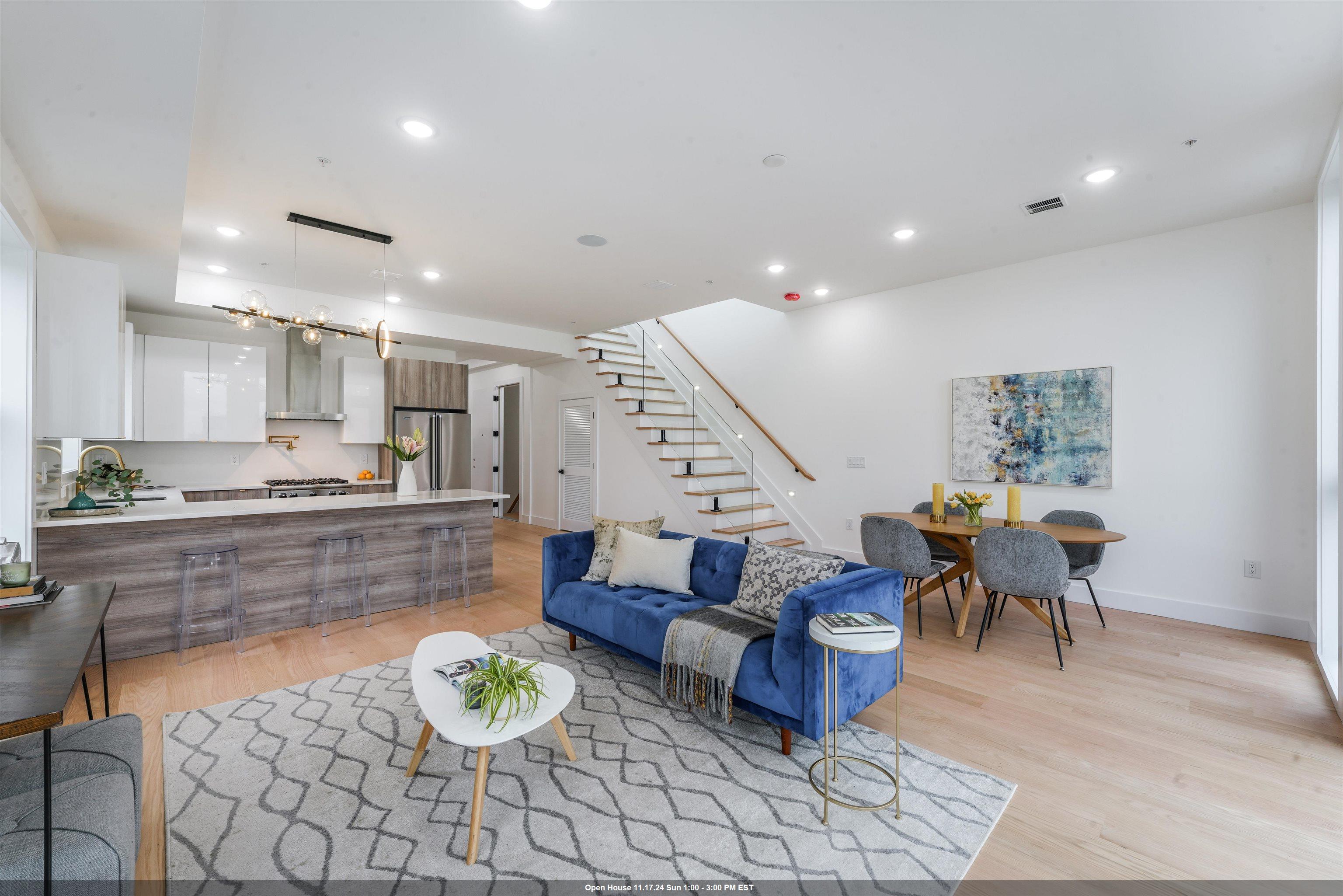 a living room with furniture and a dining table with kitchen view