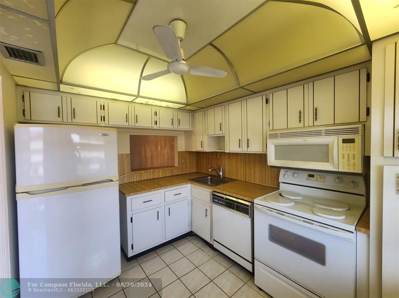 a kitchen with granite countertop a sink and cabinets