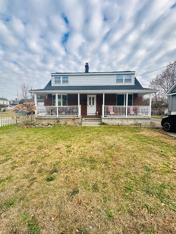 Cape Cod style home with a front yard