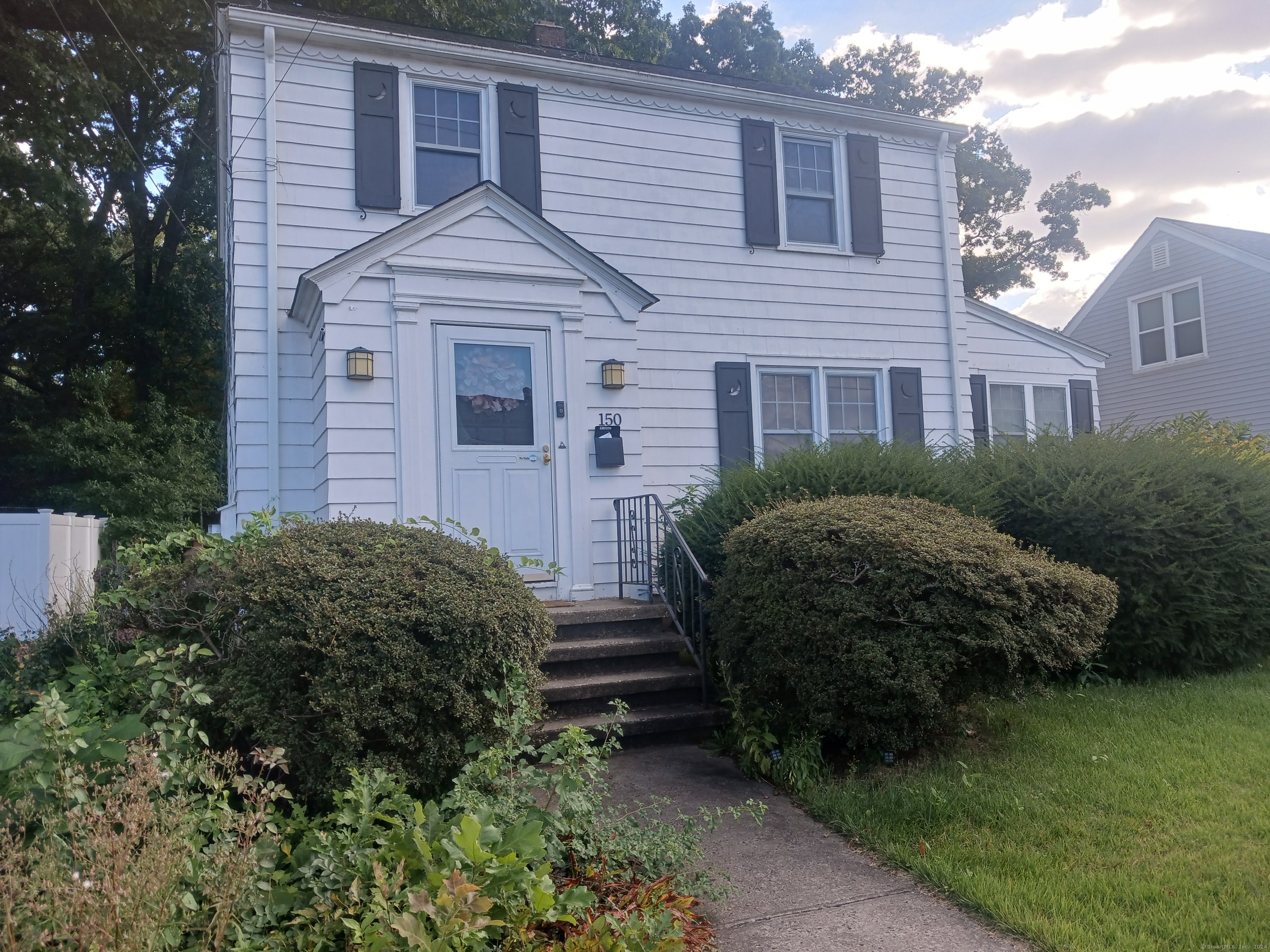 a front view of a house with a garden