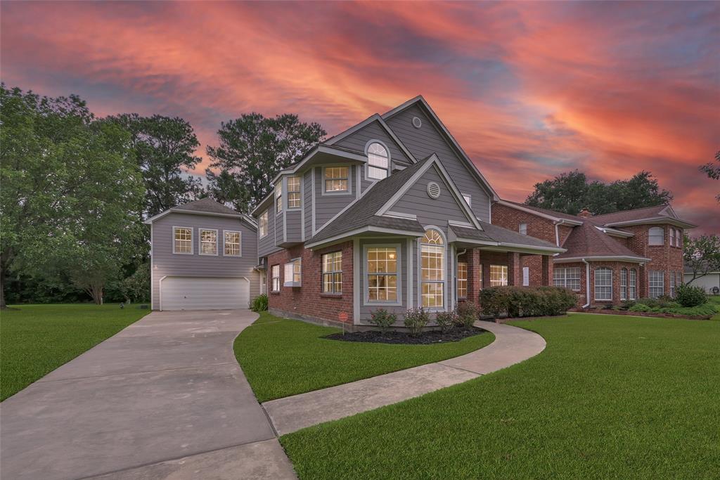 a front view of a house with a yard and green space