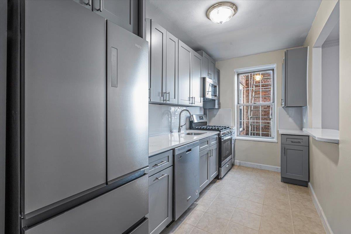 a kitchen with granite countertop a sink stove and refrigerator