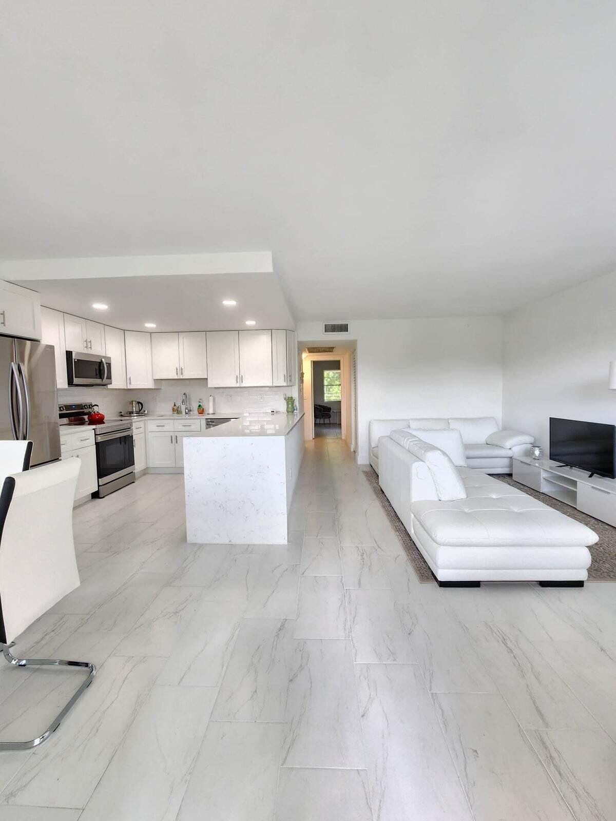 a living room with furniture and kitchen