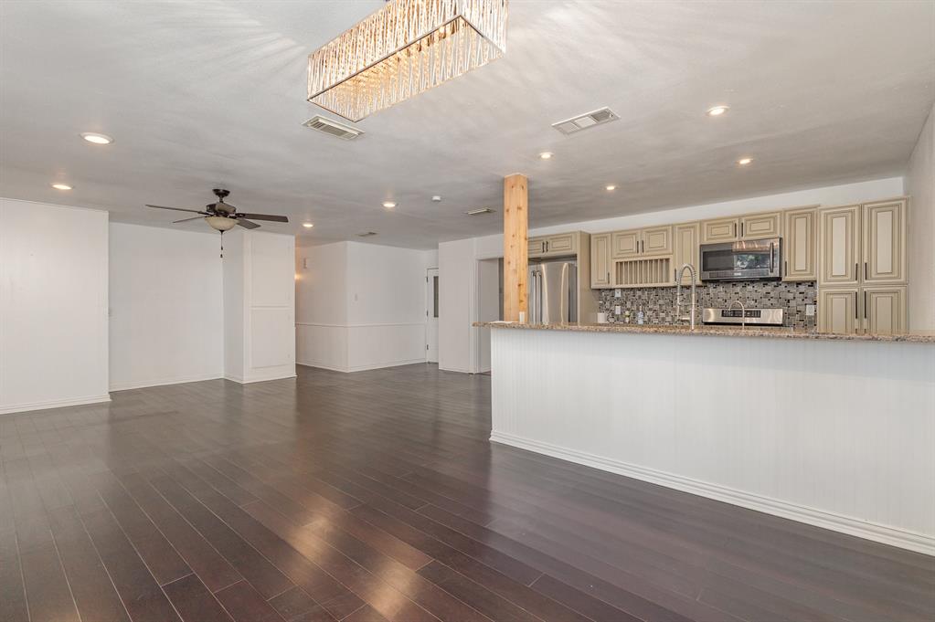 a view of kitchen with refrigerator and wooden floor