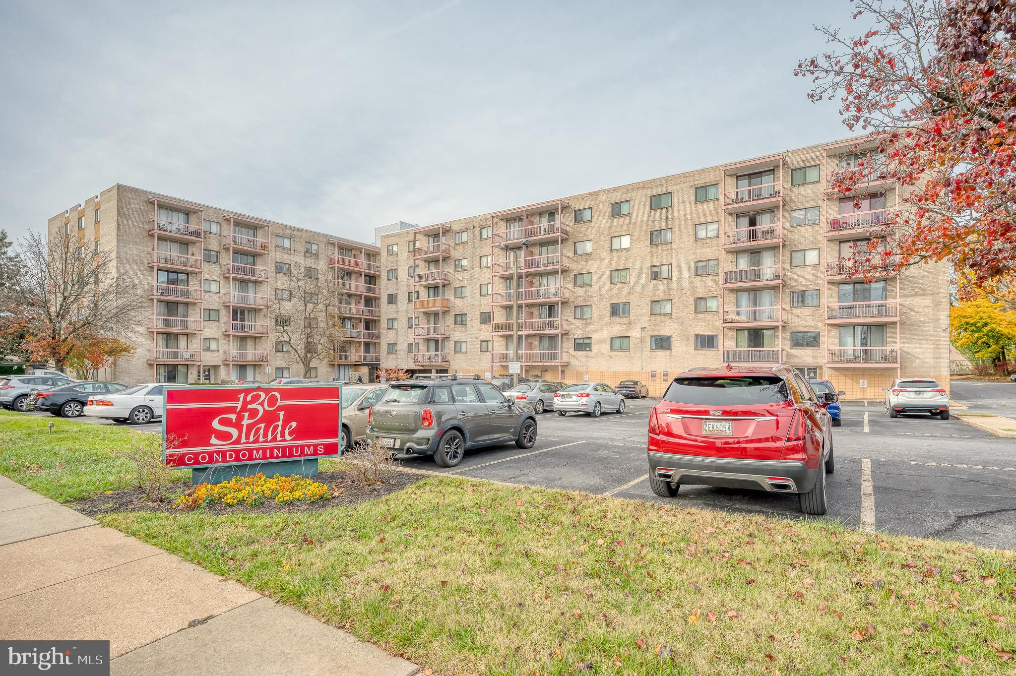 a view of a red car is parked in front of a building