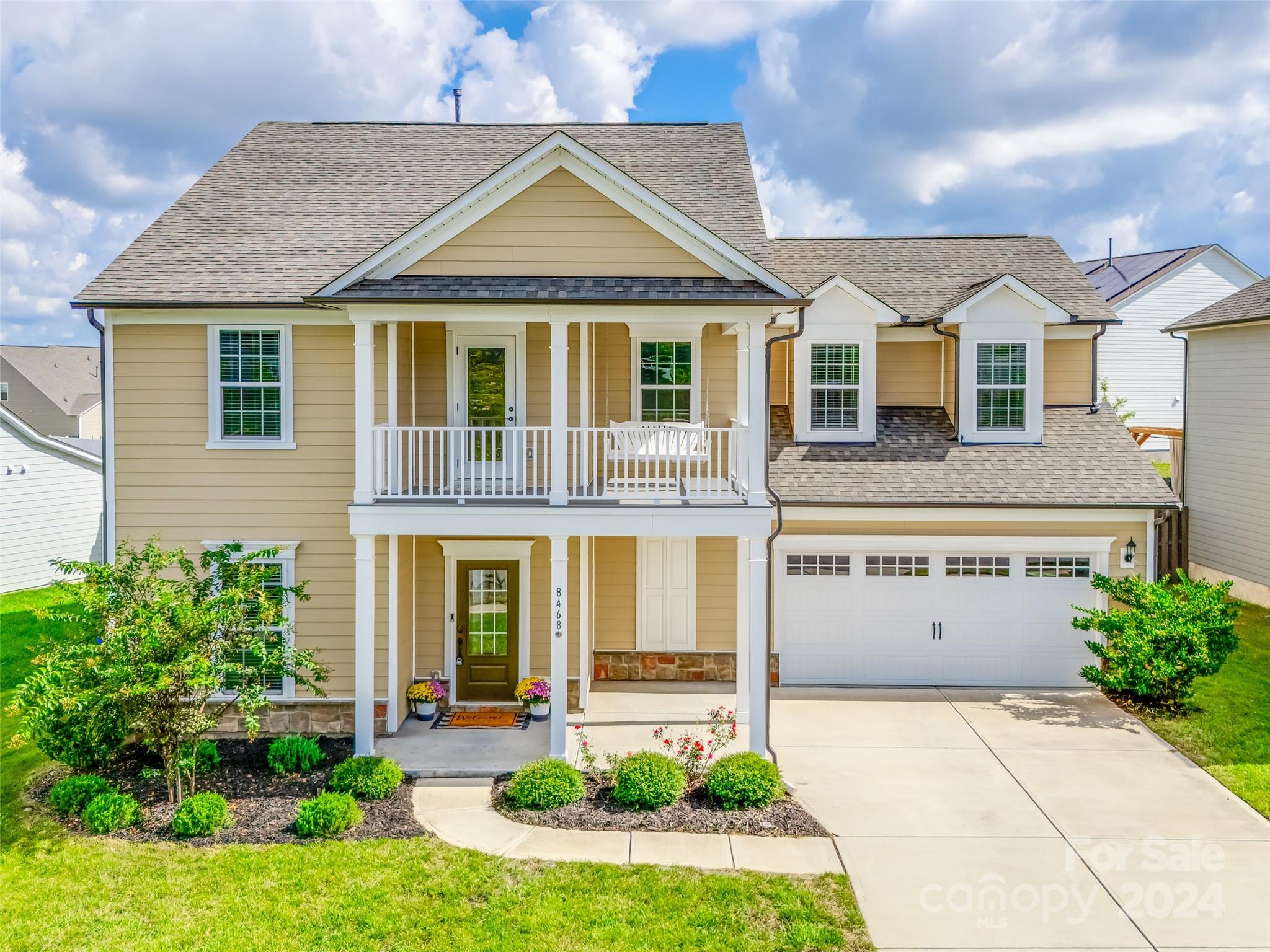 a front view of a house with a yard and potted plants