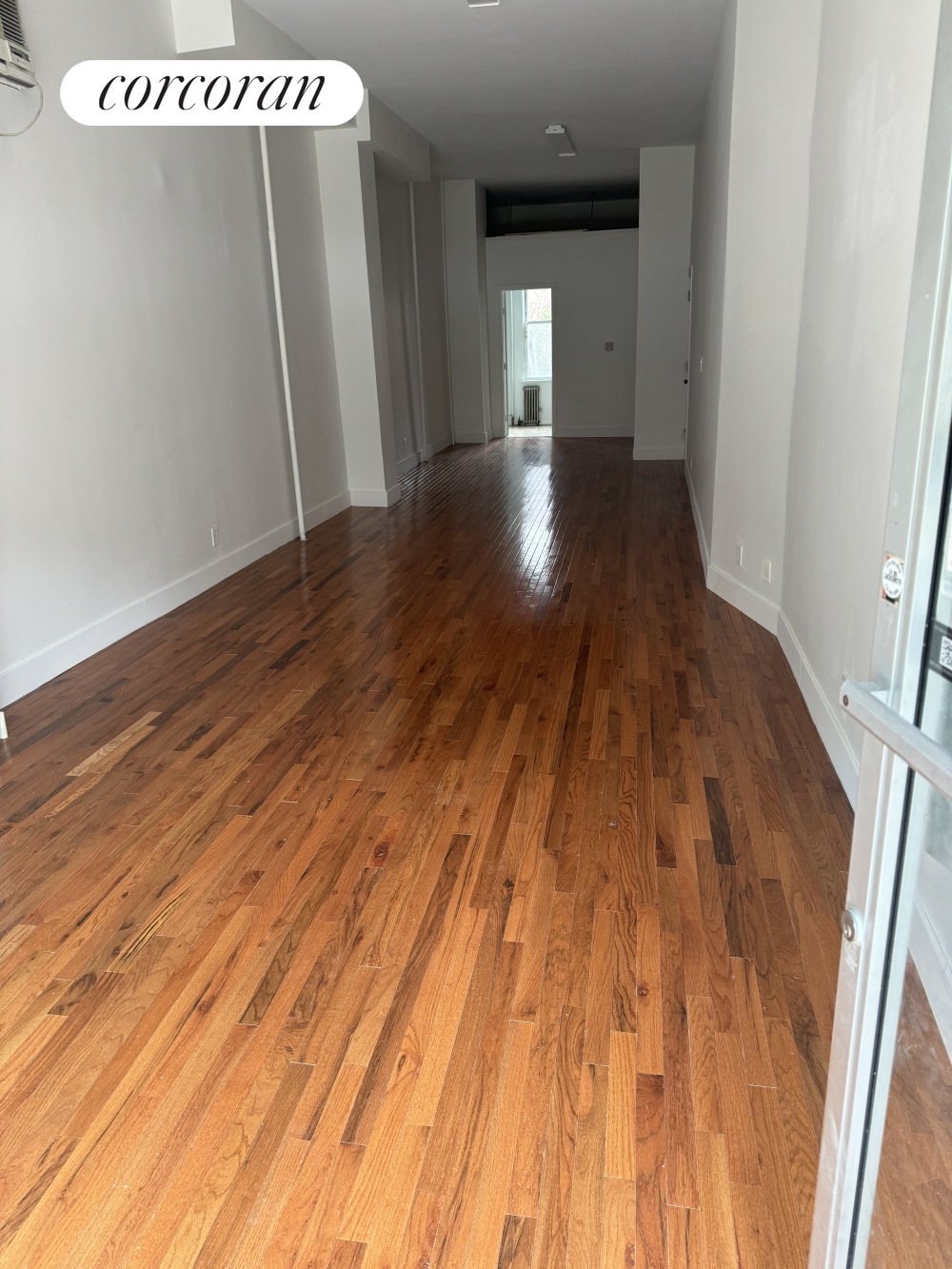 a view of a room with wooden floor and window