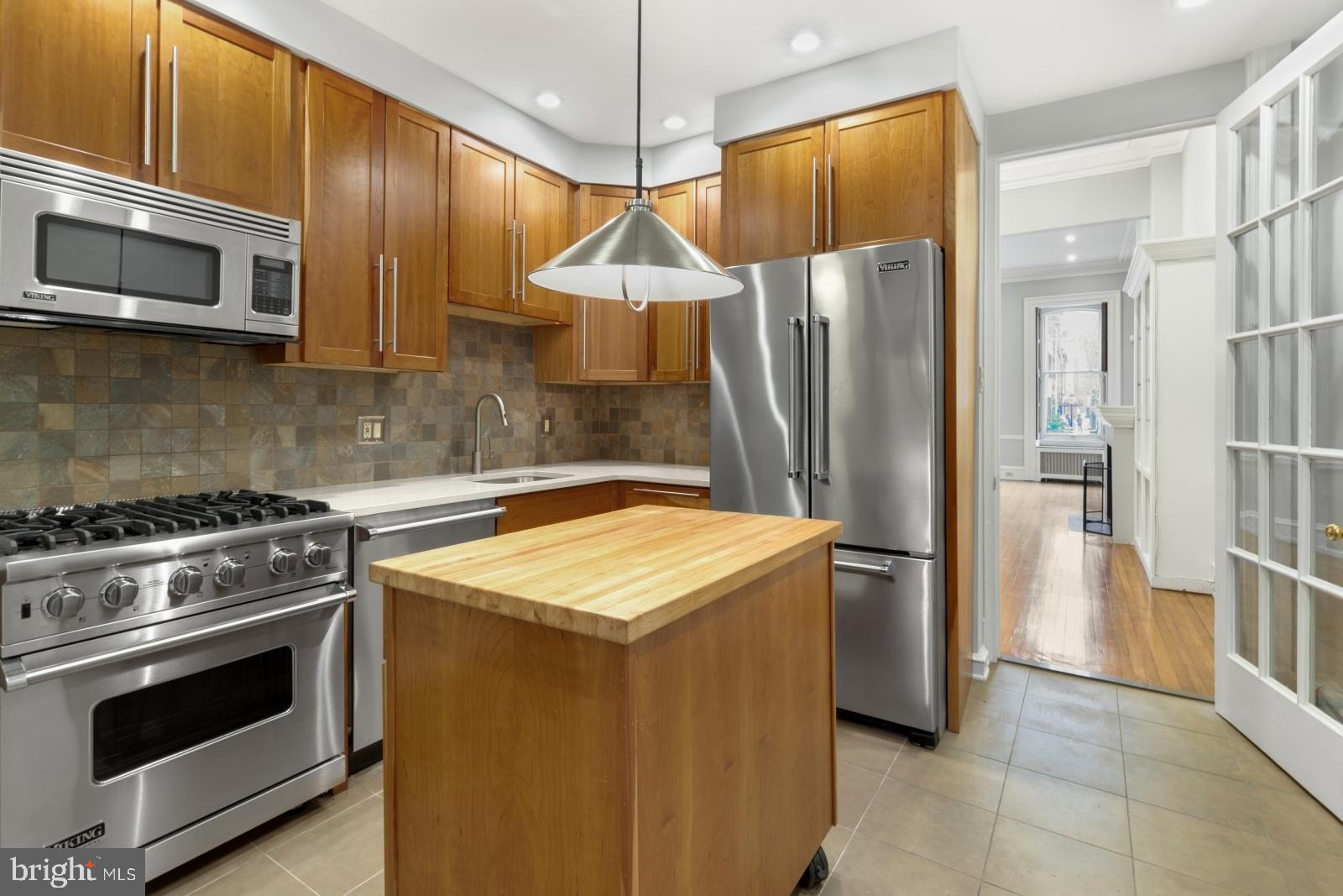 a kitchen with stainless steel appliances granite countertop a refrigerator stove and sink