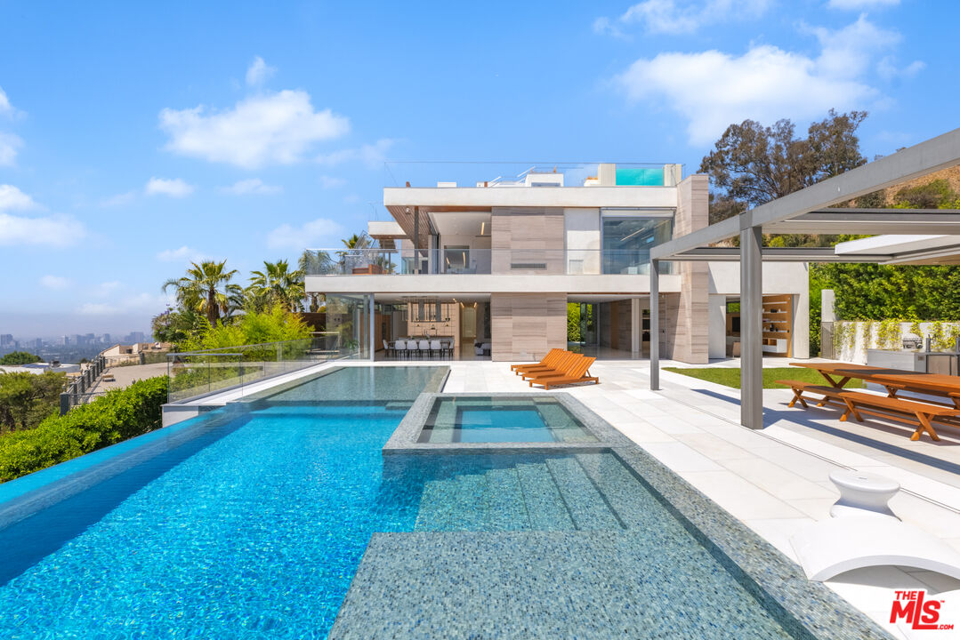 a view of a house with swimming pool and sitting area