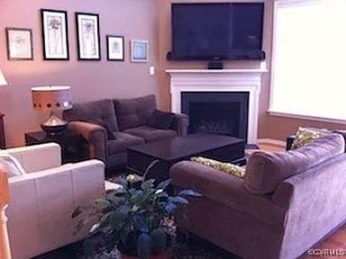 a living room with furniture fireplace and a window