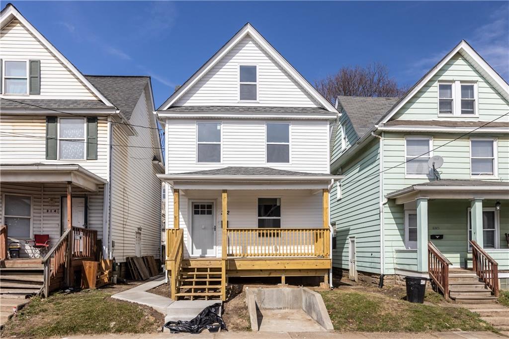 a view of a house with a yard and seating space