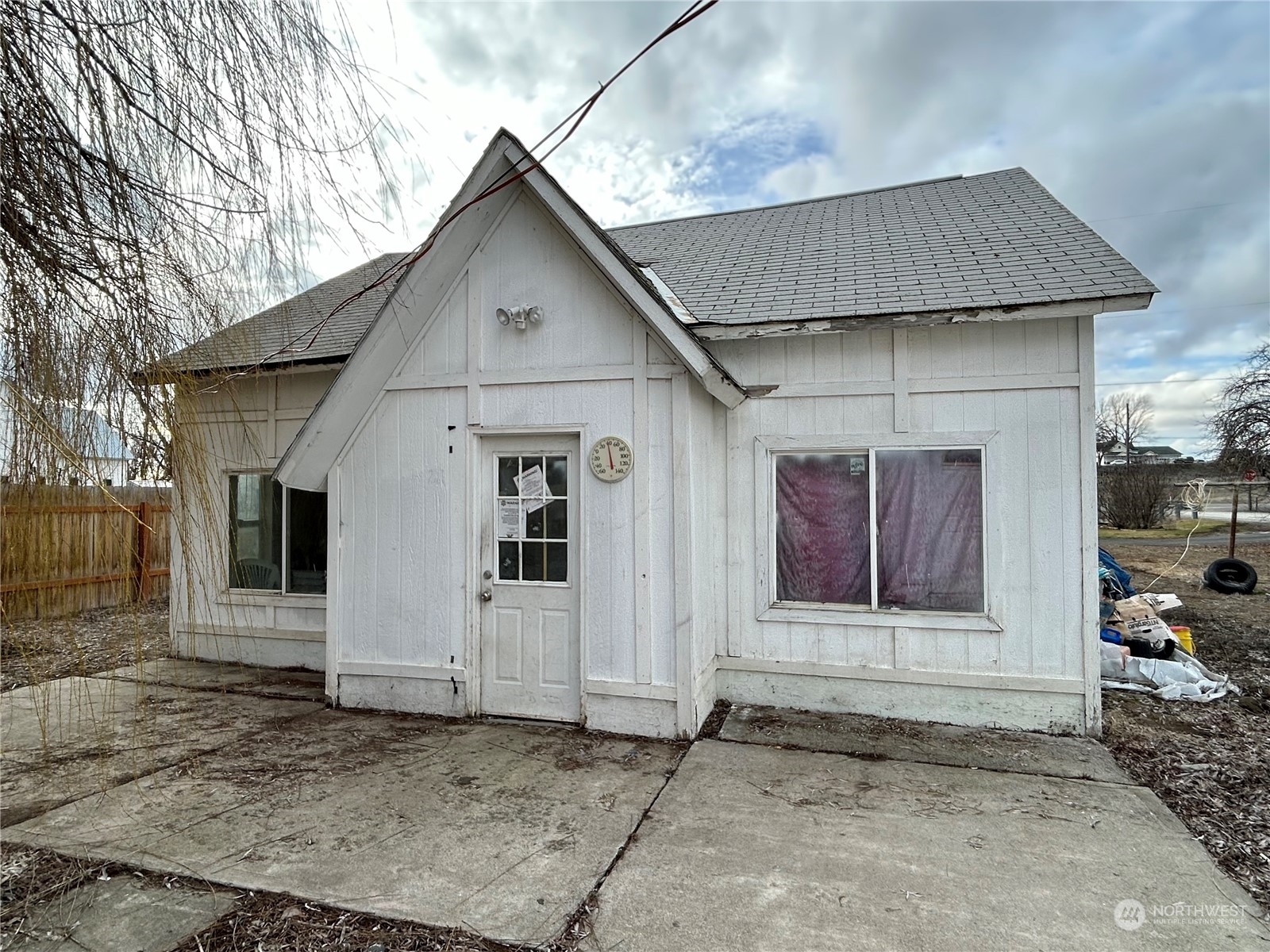 a front view of a house with white fence