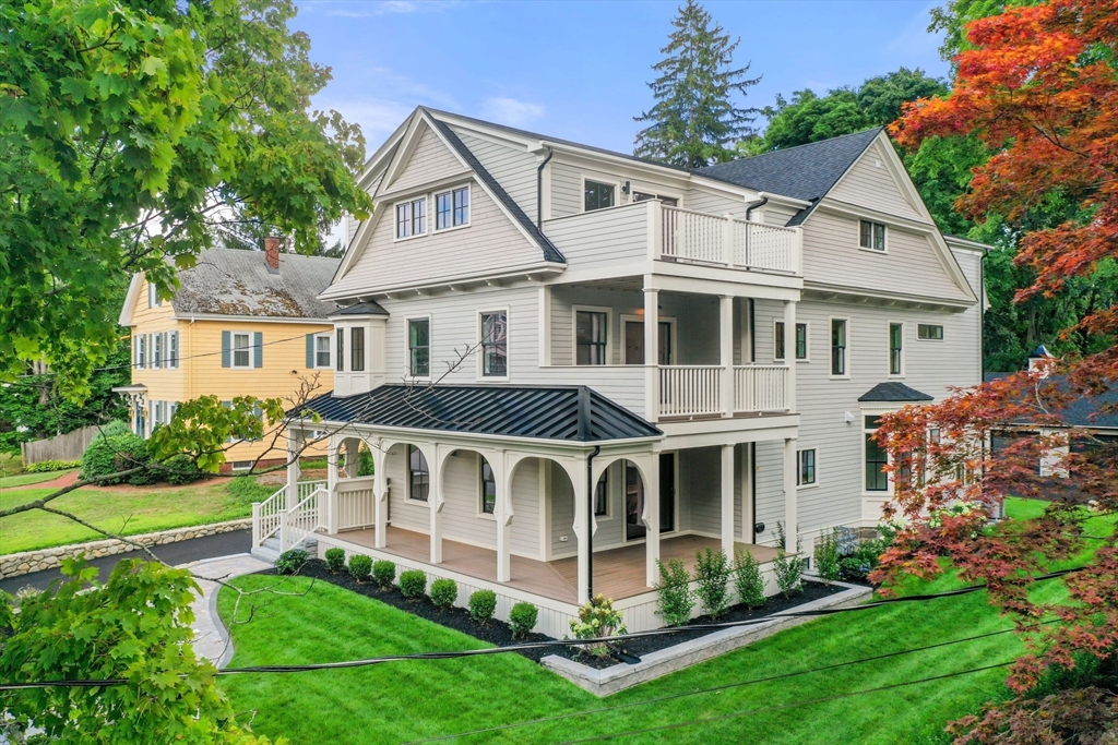 a view of a white house with a big yard and large trees