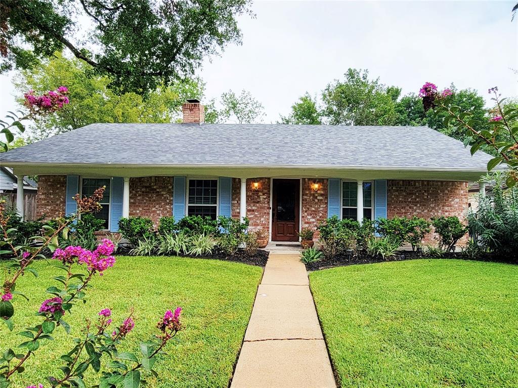 a front view of a house with a yard and potted plants