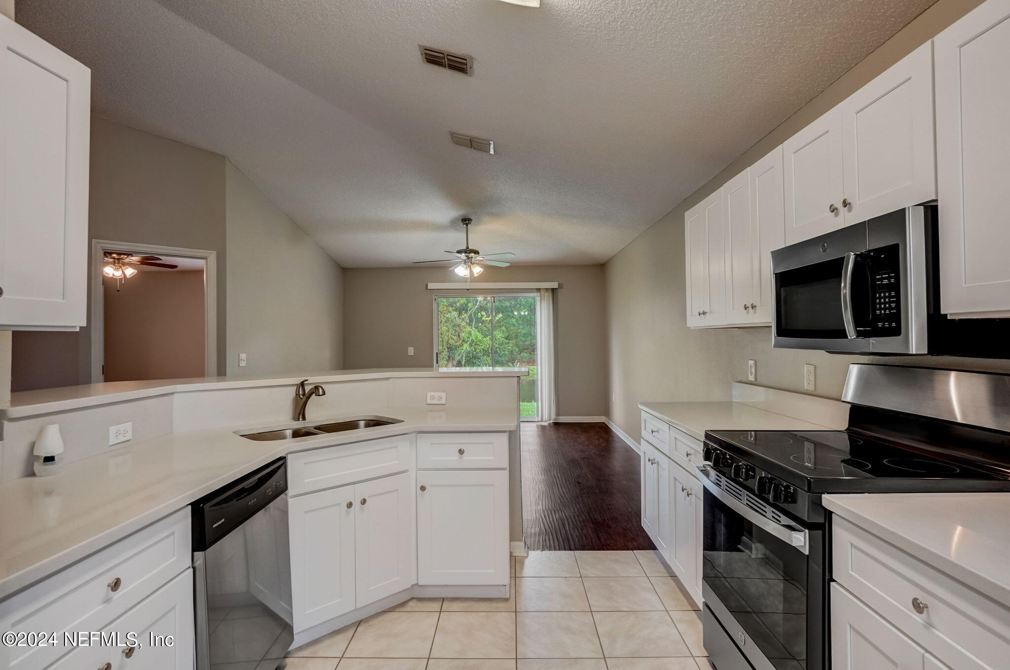 a kitchen with a sink stove and microwave