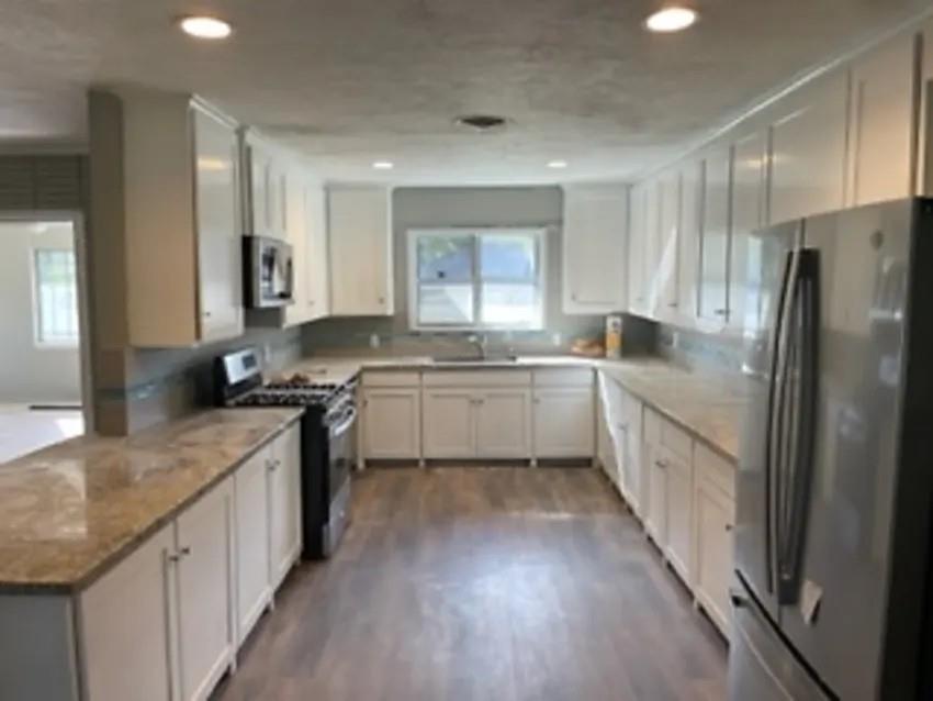 a kitchen with a sink stove cabinets and refrigerator