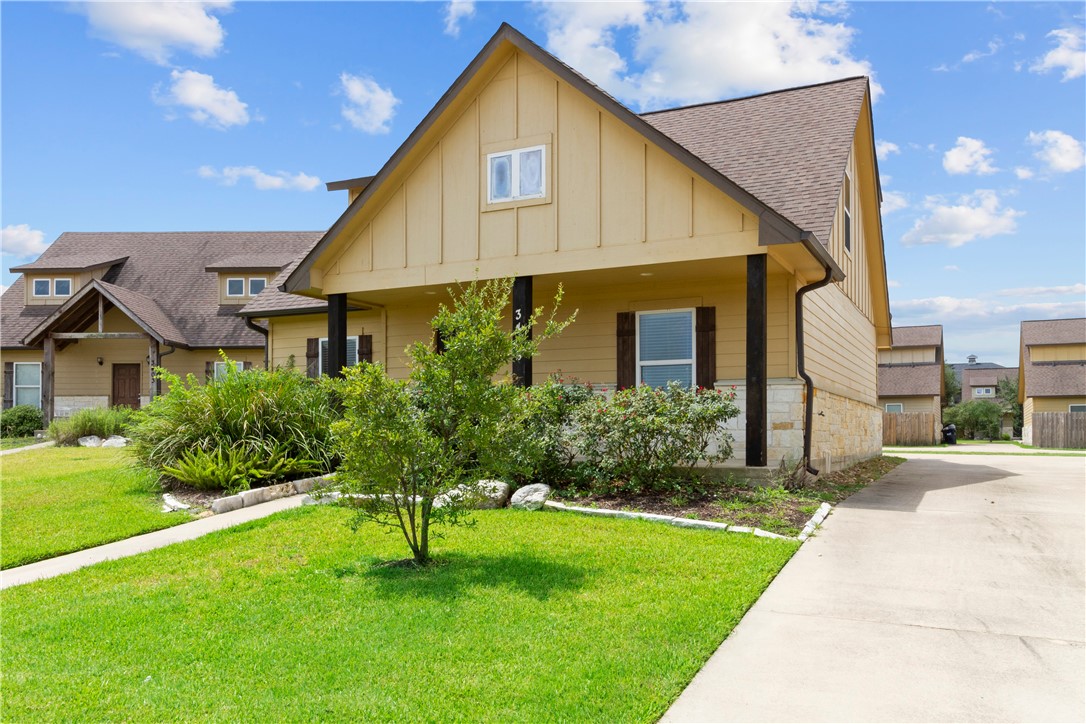 a front view of a house with a yard and trees