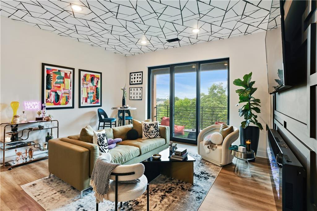 a living room with furniture a flat screen tv and a large window