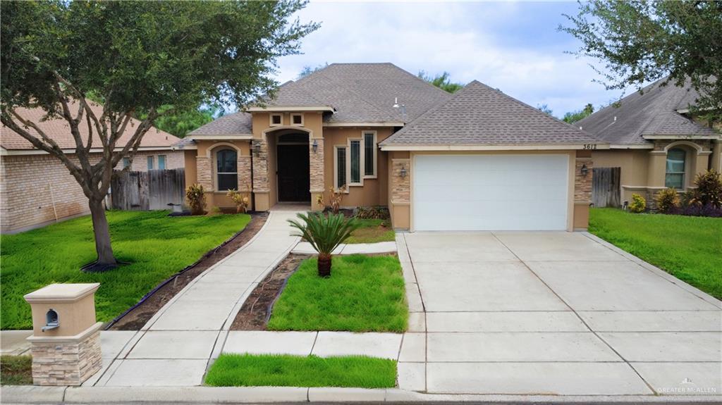 a front view of a house with a yard and potted plants