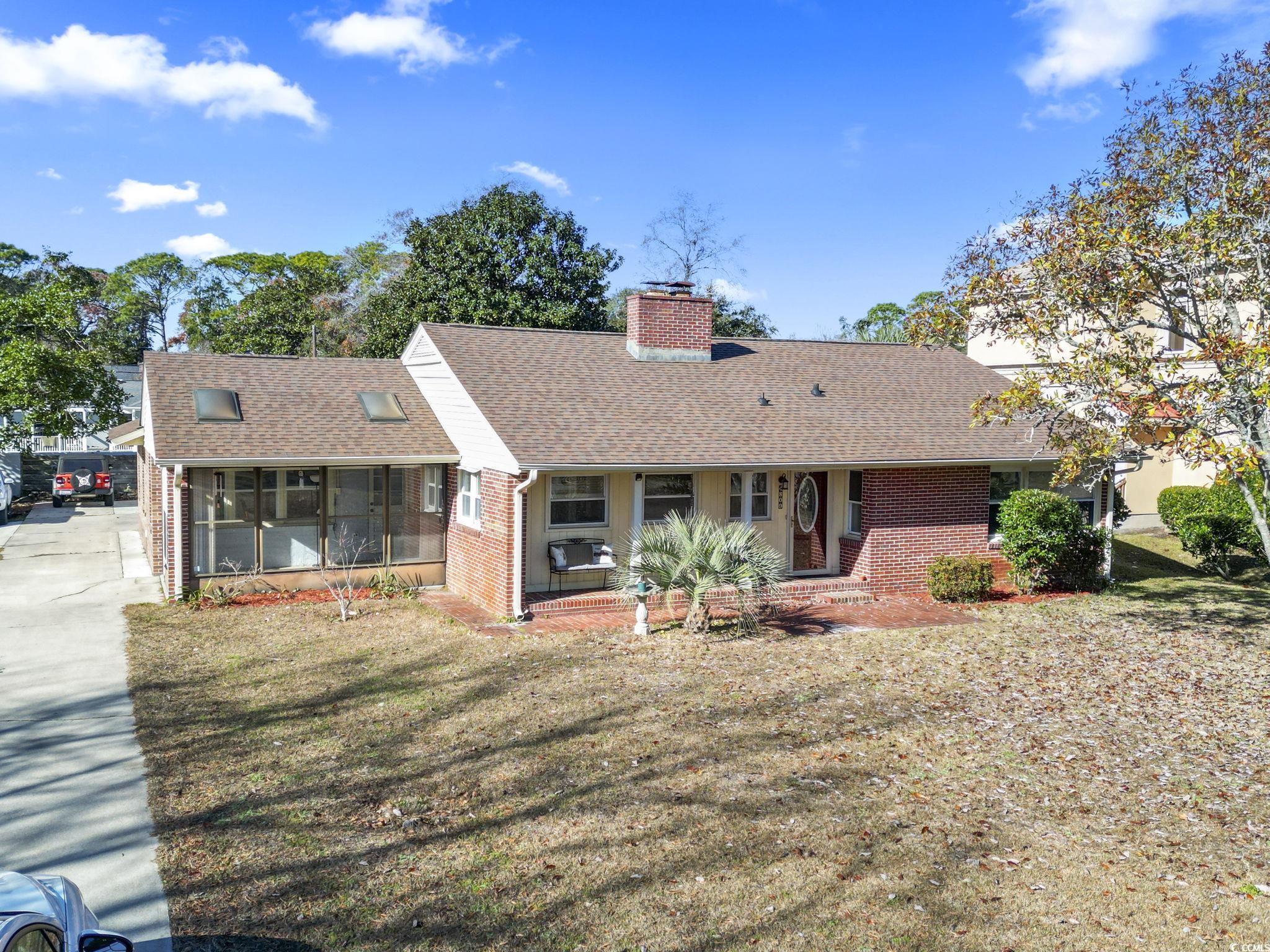 Ranch-style home with a sunroom and a front yard