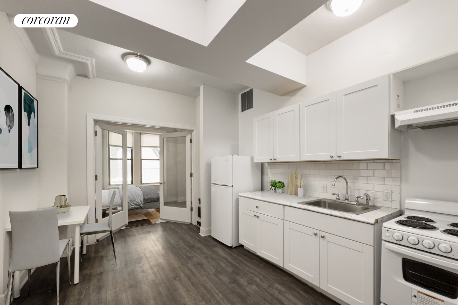 a kitchen with a white cabinets and wooden floor