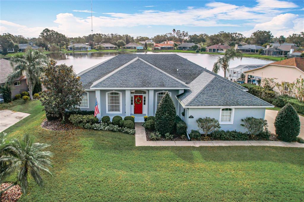 a aerial view of a house next to a yard and lake view